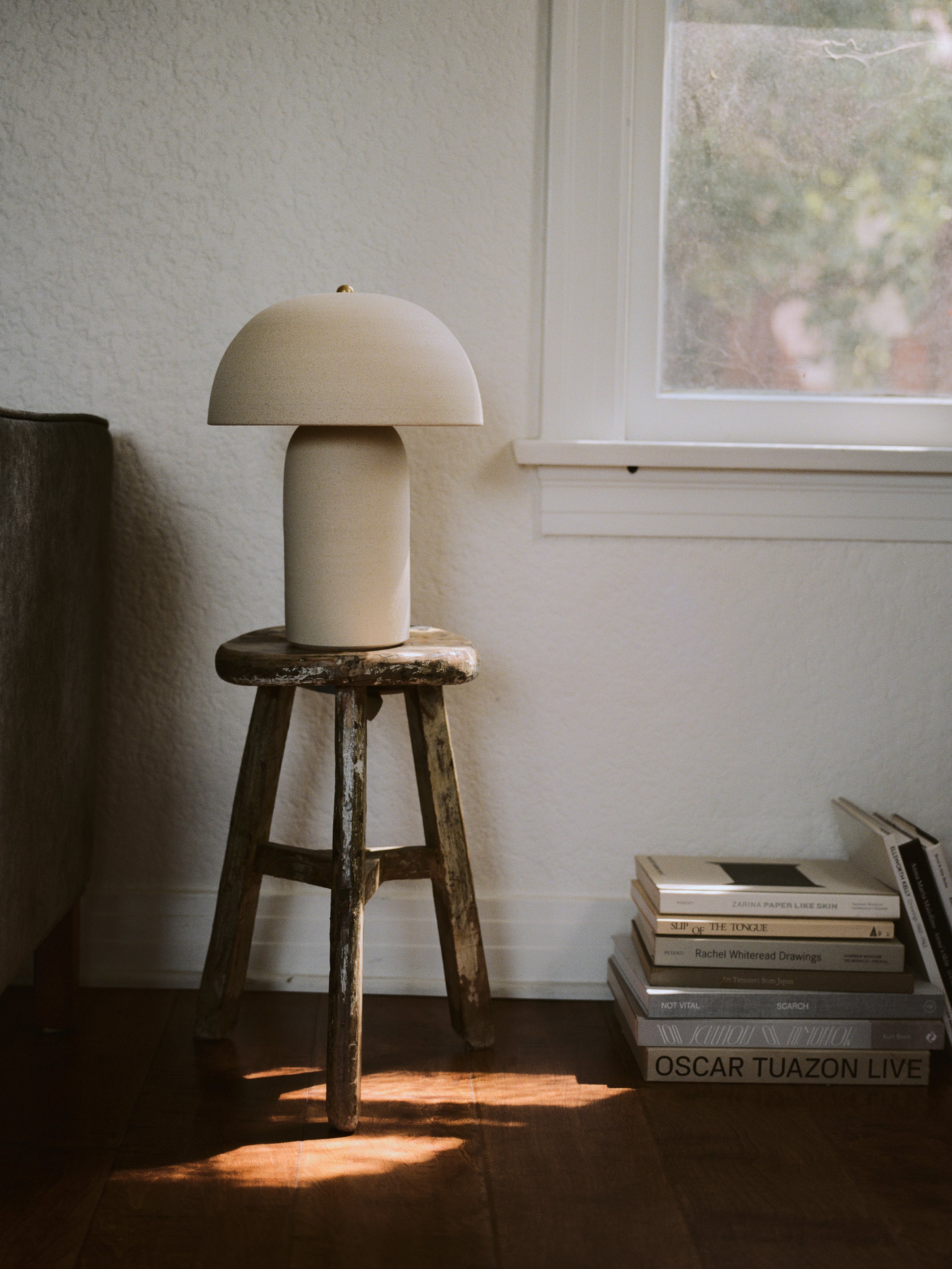 Ceramicah Tera Lamp Unglazed in Stone medium on side table with books